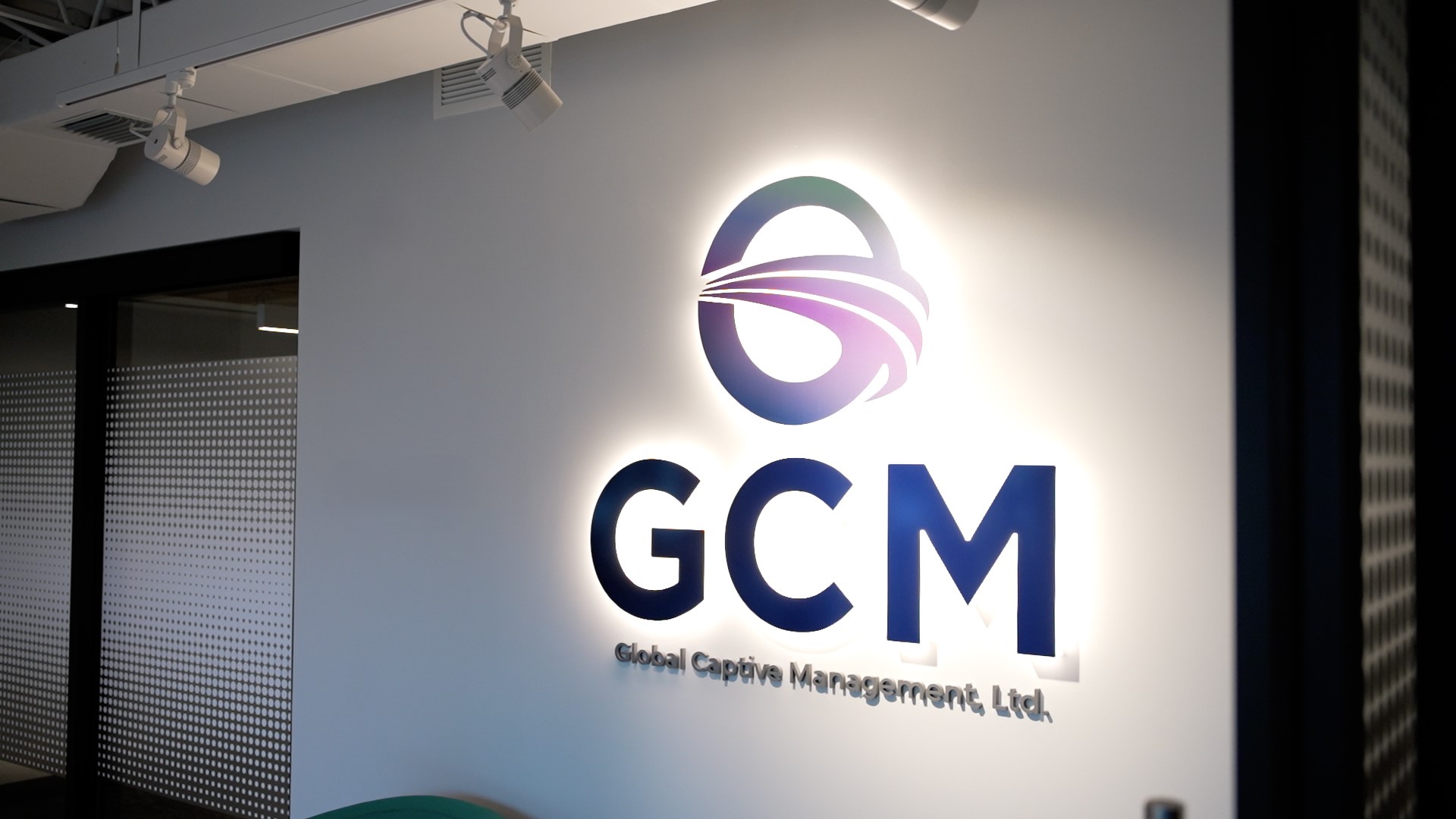 A backlit GCM logo in the GCM office.